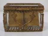 a small glass box with a gold decoration on it