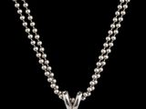 un pendentif en diamant suspendu à une chaîne à maillons ronds sur fond noir