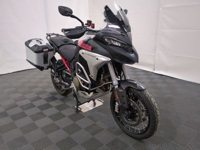 une photo d'une moto noire et rouge garée dans un garage