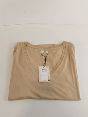 Le t-shirt est de couleur beige et comporte une étiquette.