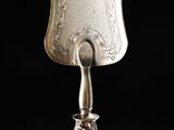 an antique silver plate with a handle and handle on a black background