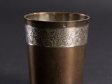 a close up of a metal cup on a black surface