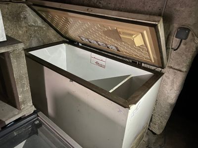 un réfrigérateur ouvert qui se trouve dans une pièce sale