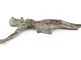 bronze statue of a woman laying on her back on a white surface