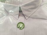 shirt in a plastic bag with a green label on it