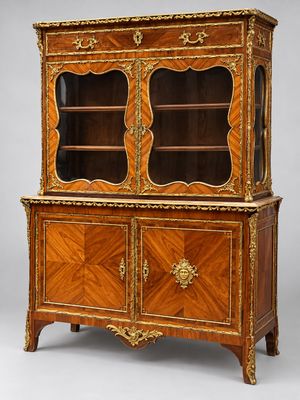 une armoire ancienne en bois à deux portes, dont l'une est vitrée