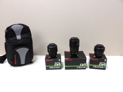 three cameras are sitting on a table next to a camera bag