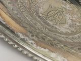 a silver plate with a bird on it on a table