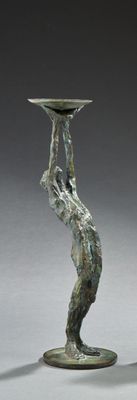une sculpture en bronze représentant une femme tenant un bol sur la tête
