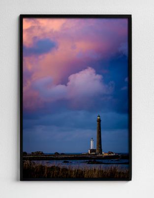 photo encadrée représentant un phare se détachant sur un ciel nuageux au coucher du soleil