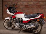 a red and white motorcycle parked in front of a brick wall