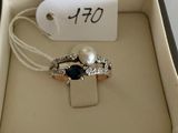 a box with a ring and a ring with a pearl on it