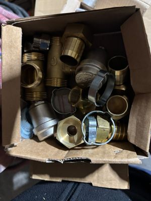 a cardboard box full of brass pipes and fittings