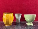 trois vases posés sur une table l'un à côté de l'autre