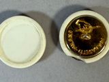 a small white plate with a gold lid and a small white plate with a gold lid