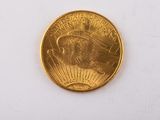 gros plan d'une pièce d'or sur une surface blanche