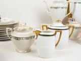 a lot of white and gold tea and coffee sets on the table