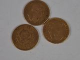 three british coins sitting on top of each other on a white surface