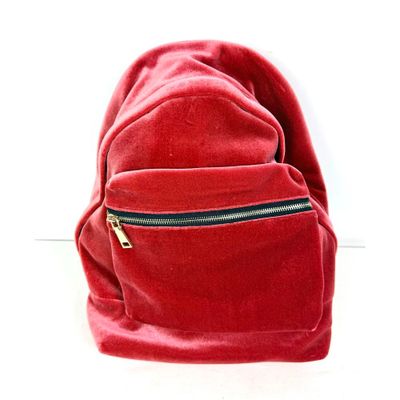 un sac à dos rouge posé sur une surface blanche