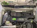une boîte contenant une perceuse filaire, posée par terre