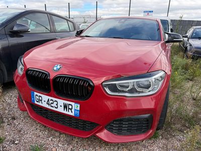 une BMW rouge garée sur un parking avec d'autres voitures