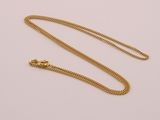 a gold necklace with a chain on a white background