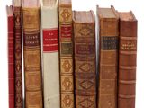 plusieurs vieux livres sont alignés sur une surface blanche