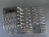 de nombreuses fourchettes et cuillères disposées sur la table