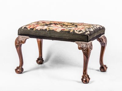 un petit repose-pieds orné d'un motif floral