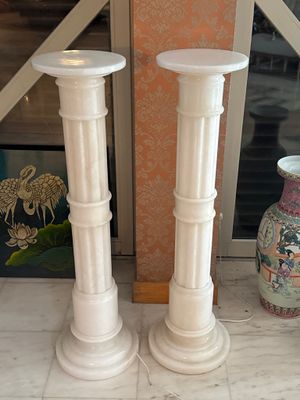 deux grands vases blancs posés par terre l'un à côté de l'autre