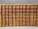 several old books are lined up in a row on a table