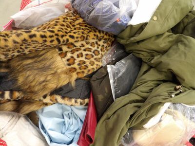 a cat laying in a pile of clothes on the floor