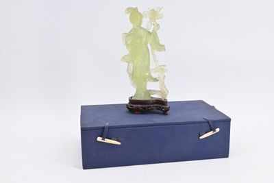 statue d'une femme posée sur une boîte bleue contenant une plante