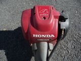 une photo d'une tondeuse à gazon Honda rouge posée par terre