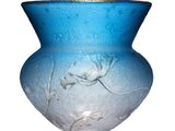 un vase en verre bleu orné d'un motif floral