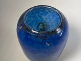 a blue vase that is sitting on a white surface