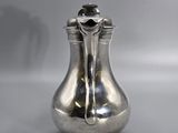 a silver vase that is sitting on a table