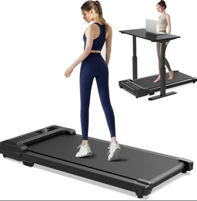 the woman is standing on a treadmill while using her laptop