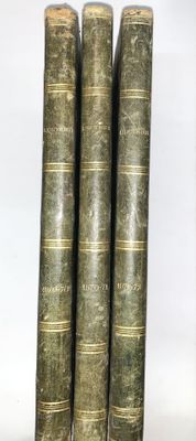 trois vieux livres sont empilés sur une table