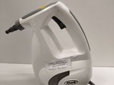 a white and black steam iron on a white table