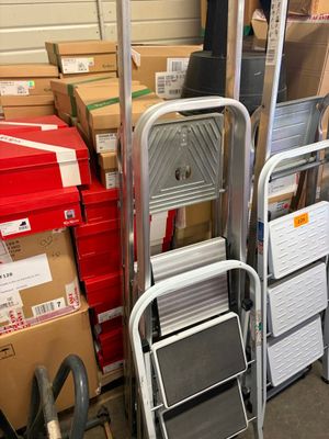 une pile de chaises et une échelle dans un entrepôt