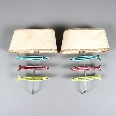 three different colored fish hanging on a hook on the wall