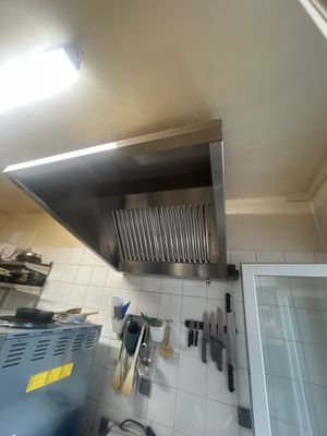 une photo d'une cuisine où de nombreux ustensiles sont suspendus au plafond