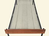 a bed with a metal frame and a wooden headboard