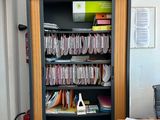 une bibliothèque remplie de livres et de papiers dans une pièce