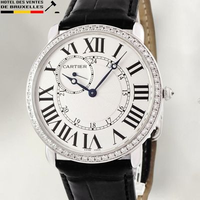 the watch is white with roman numerals and black leather straps