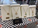 three necklaces are on display in a display case at a jewelry store