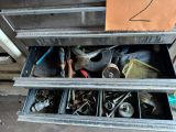 une armoire métallique contenant des outils, avec une pancarte sur la porte