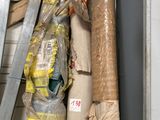 many rolls of fabric and a ladder in a storage room