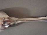 a silver spoon with a spoon handle on a table